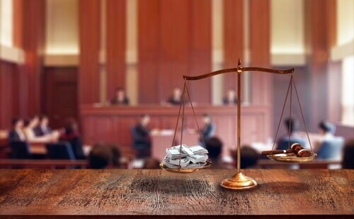 Image featuring scales inside a court room trial